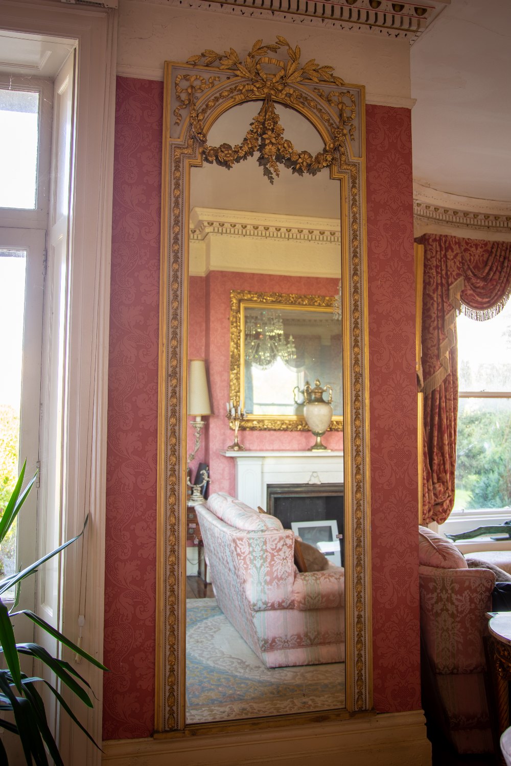 A very attractive painted and parcel gilt Pier or Console Mirror, with ribbon bow crest issuing leaf