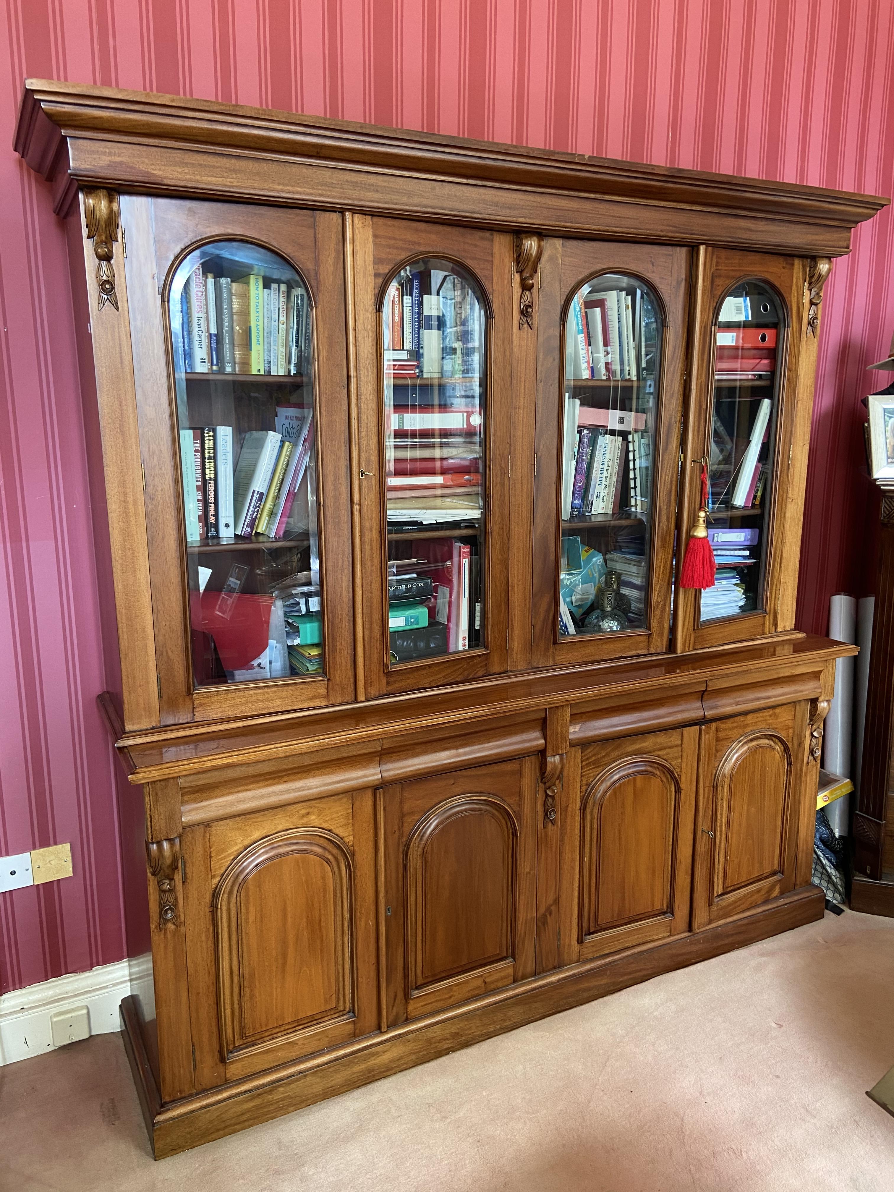 A Victorian style mahogany Library Bookcase, with moulded pediment above four arched and glazed