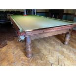 A full size Billiard / Snooker Table, in mahogany and covered in green baize raised on 8 heavy