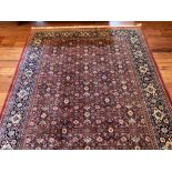 A fine large Turkish Rug, with all over floral pattern on a burgundy ground inside a navy border