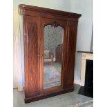 A Victorian mahogany mirror door Wardrobe, with moulded pediment and fitted interior on a plinth