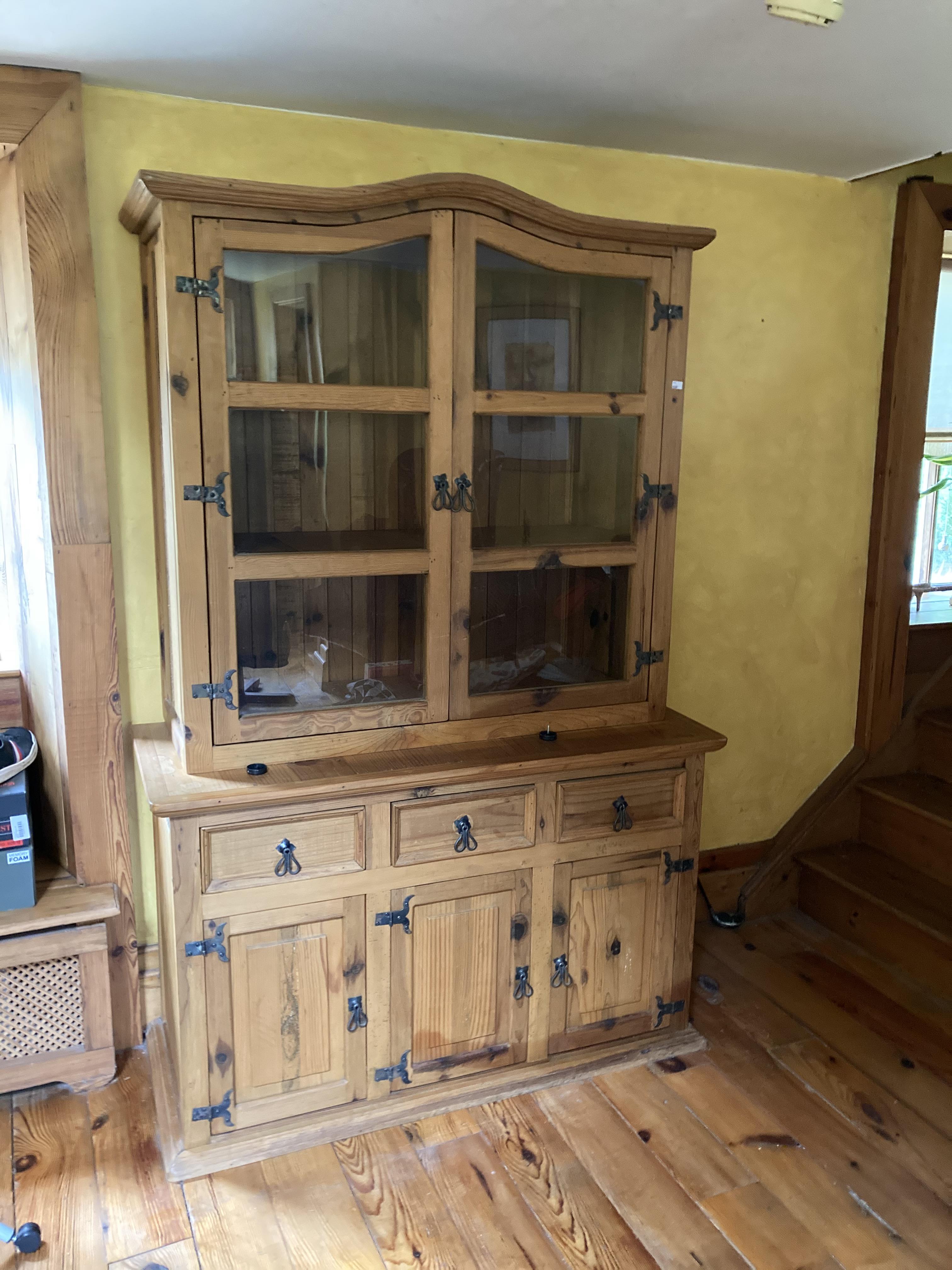 A pine Kitchen Cupboard, with arched top, glazed doors, on a base with drawers and presses,