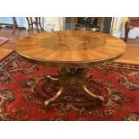 A Victorian oval inlaid walnut Loo Table, on four fluted and turned stems on a quadruple pod with