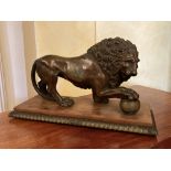 A bronze Figure of a Medici Lion, with right front paw on a sphere, on bronze and wooden base,