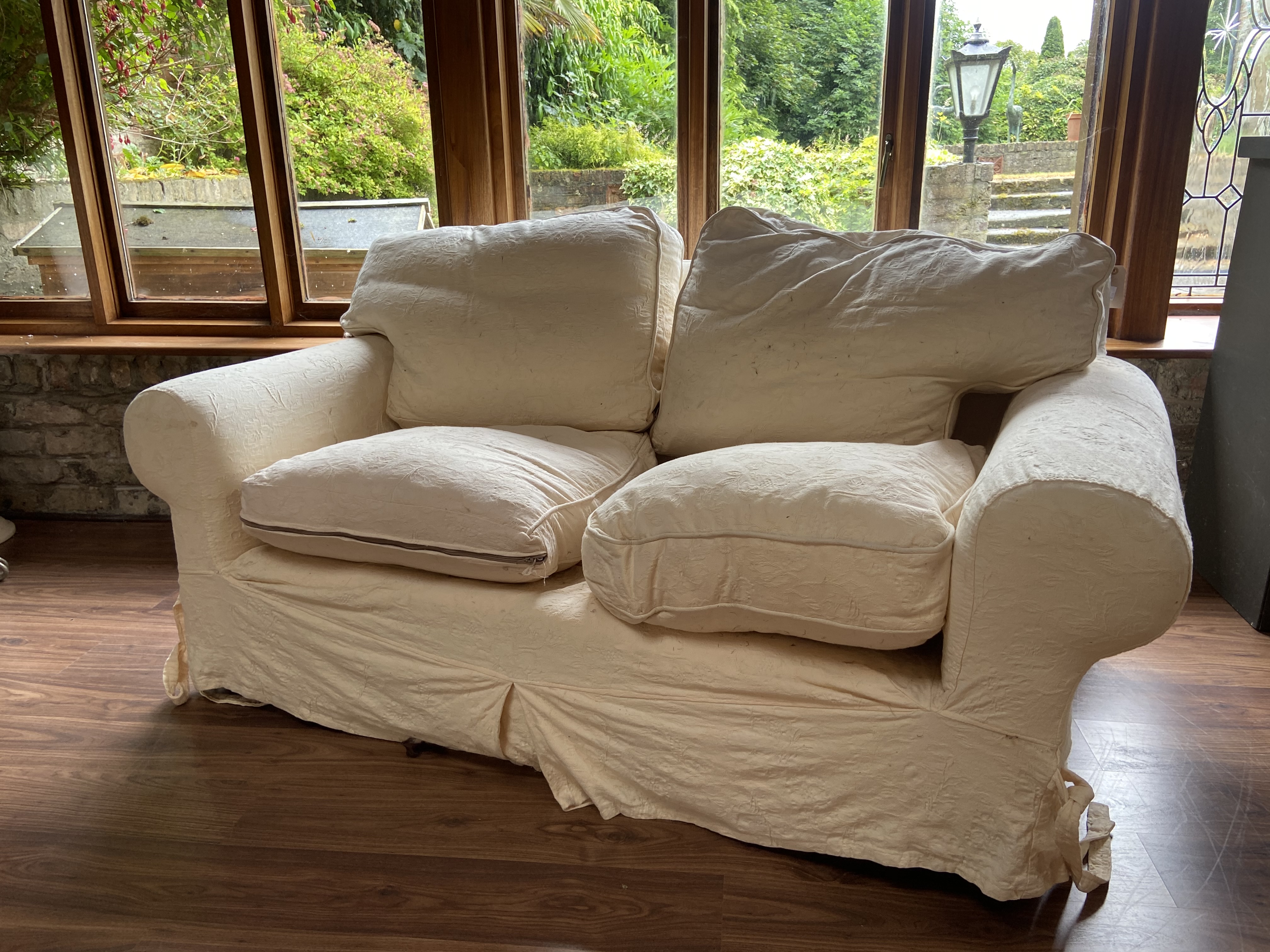 A 2 piece Suite of Seat Furniture, comprising a two seater Settee, covered in ivory loose fabric and