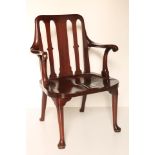 An early 19th Century mahogany Open Armchair, possibly Irish, with slatted back and saddle seat,