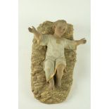 A very good 19th Century terracotta polychrome Figure, of the Infant Jesus lying in a a cradle of