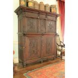 An 18th Century oak Armoire, probably German, the moulded cornice above a frieze with grotesque mask
