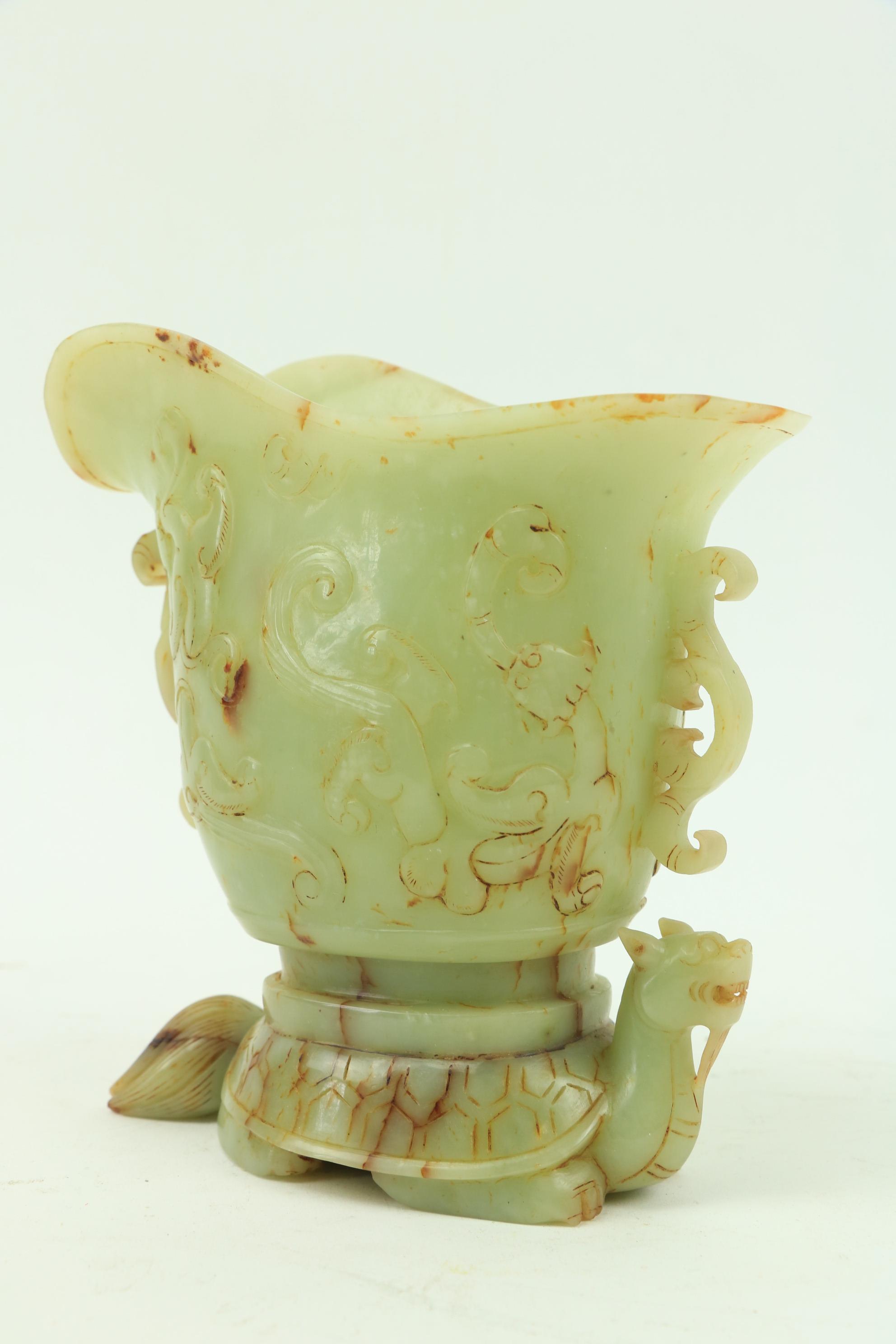 A fine carved Chinese jade Libation Cup, carved in relief with scrolls under a double spout and