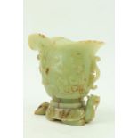 A fine carved Chinese jade Libation Cup, carved in relief with scrolls under a double spout and