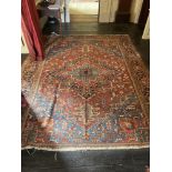 A large PersianÿCarpet, with diamond medallion and all-over geometric designs, on iron red ground