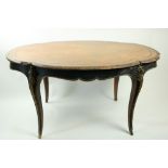 An oval serpentine shaped French Centre Table, with ornate brass mounts and ebonised crossbanding on