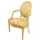 A George III cream painted and parcel gilt Open Armchair, with moulded oval padded back and