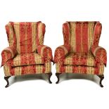 A pair of Georgian style wing back Armchairs, covered in red and green damask fabric with loose