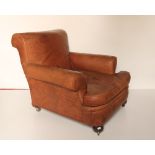 A pair of tan hide covered Club Type Armchairs, in the style of Howard, London, with loose cushion