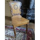 A set of three Victorian heavy oak shield back Hall Chairs, the shaped and carved backs over plain