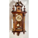 Inlaid Vienna wall clock with eagle top, pendulum and key. 33”(84cm) long x 10” (25cm) wide