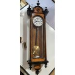 Double weight Vienna walnut wall clock with pendulum. 50” (127cm) length x 10.5” (27cm) wide.