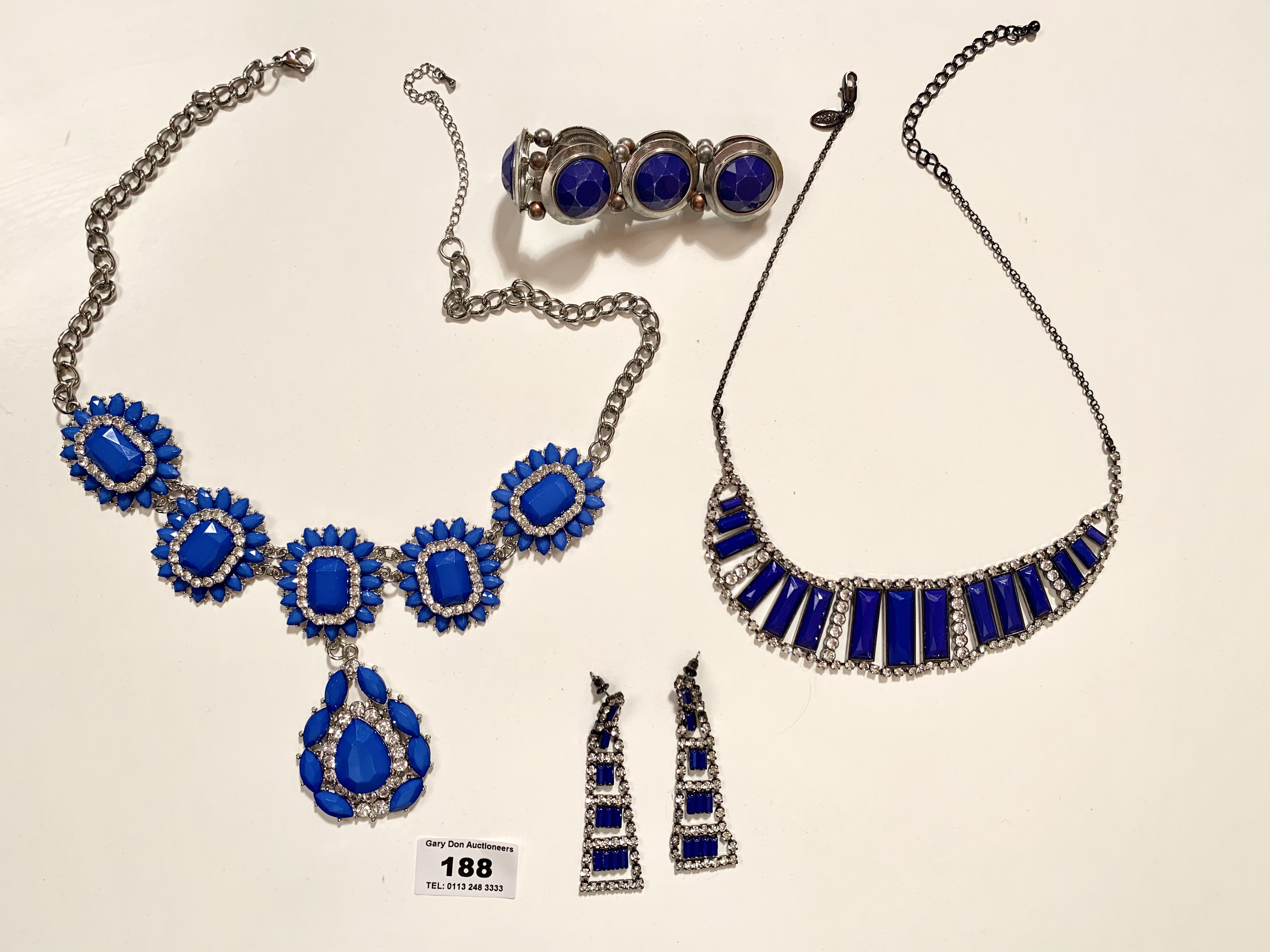 2 blue dress necklaces, pair of blue dress earrings and blue dress bracelet