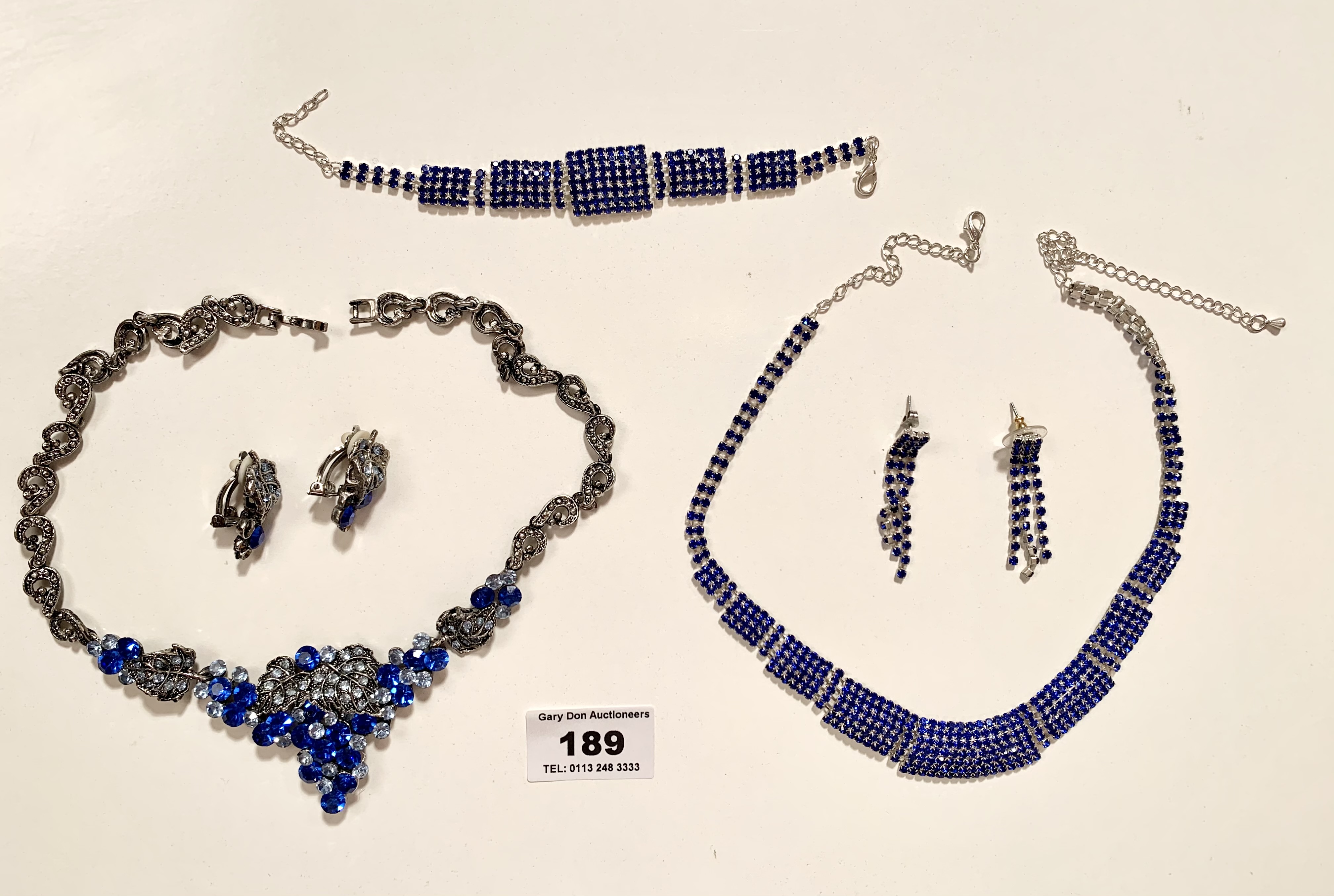 2 sets of blue dress necklaces, bracelets and earrings