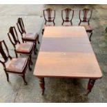 Large Victorian mahogany wind-out table with 2 leaves and 6 mahogany shield back chairs with leather
