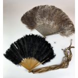 2 large feather fans, grey one in good condition, black fan is separating