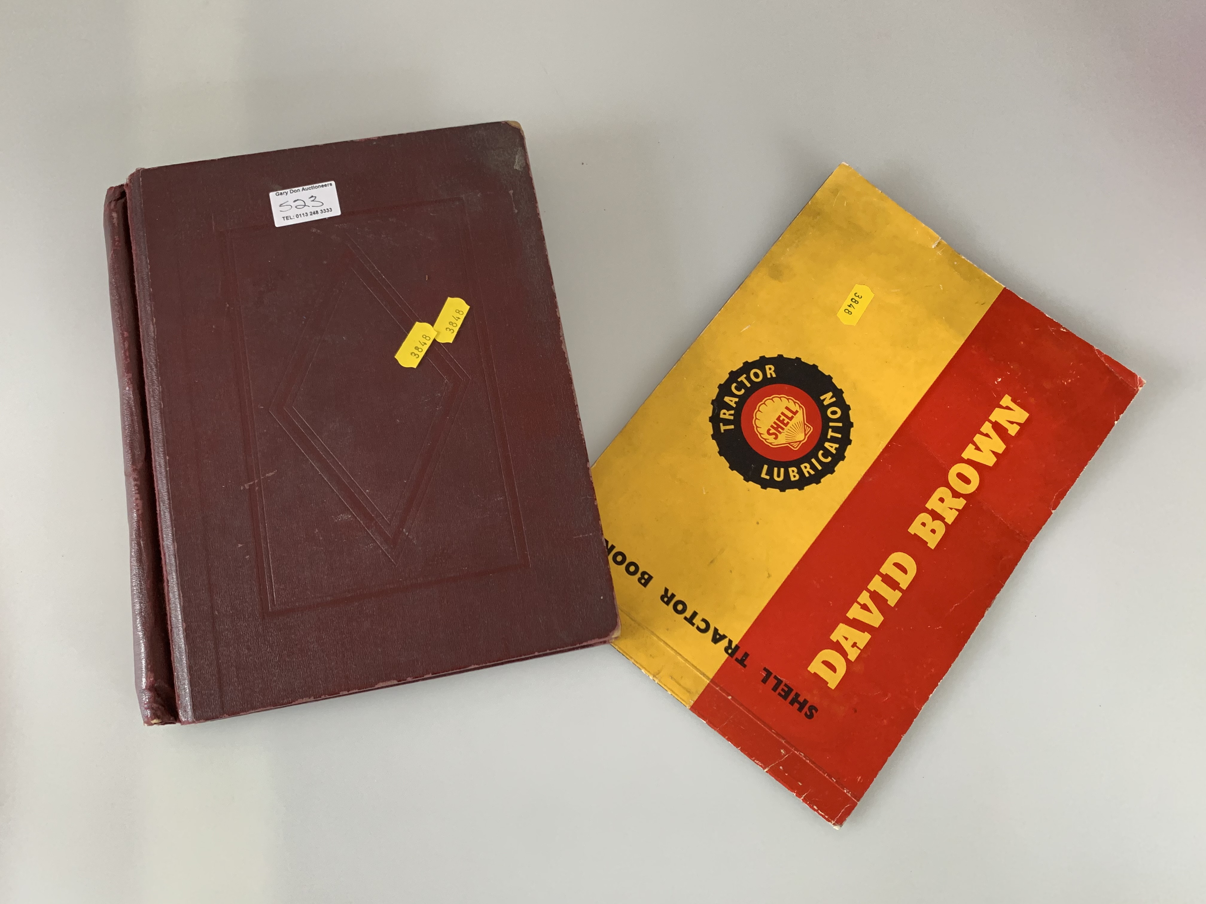 Brown album and Trusty album of world stamps and a David Brown Tractor book