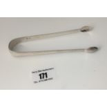 Pair of silver sugar tongs, engraved S.N. 5.5” long, w: 0.9 ozt