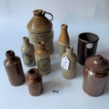 7 stoneware advertising bottles and 2 stoneware jars