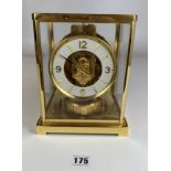 Jaeger-LeCoultre Atmos clock with white and brass dial and set under brass and glass case. 9” high x