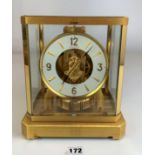 Jaeger-LeCoultre Atmos clock with white and brass dial and set under brass and glass case. 9.5” high