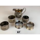 6 assorted silver napkin rings and small silver jug, total w: 9.1 ozt