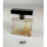 Etched glass perfume bottle with black stopper. Total height 4” x 3” wide. Small chip on rim