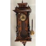 Carved Vienna wall clock with pendulum, height 42”