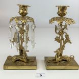 Pair of brass candlesticks with seated dog figures and lustre style drops (8 drops missing). 9”