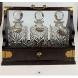 Mahogany Tantalus with brass fittings and key, with 3 cut glass bottles, 2 stoppers chipped. Port,