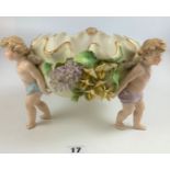 Continental china bowl with cross swords mark, held by 3 winged cherubs and decorated with