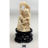 Oriental ivory group figure on carved wooden stand, figure 5.5” high, stand 2” high