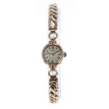 Milus 18k lady's bracelet watch, circular silvered dial with Arabic twelve and six and baton
