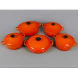 Range of quality cast iron Le Creuset lidded casserole dishes, in Volcanic Orange, including large
