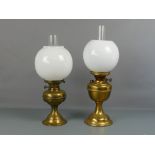 Two similar brass and glass globe top oil lamps complete with chimney, 18.5" and 20.5"