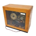 Gents of Leicester C69 programmer with bells and lights, within a light wooden glazed case, 16"