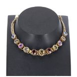 Attractive yellow metal multi-gem set bracelet, including sapphires, zircon and garnets, with safety
