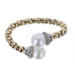 Good 18k yellow gold pearl and diamond sprung bangle, the pearl terminals each of good lustre