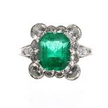 Impressive white metal emerald and diamond dress ring, the emerald 3.28ct approx, within a