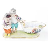 Meissen porcelain figural salt, modelled as two children by a shell form bowl, the bowl decorated