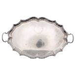 Edward VII twin-handled serpentine oval silver tray, raised on four feet, maker Charles Stuart