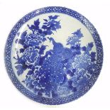 Chinese blue and white porcelain charger, decorated with a peacock among flowers and foliage