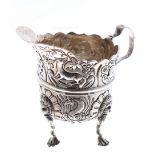 Irish late 19th century silver cream jug, repousse decorated with animals among flowers and a vacant