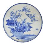 Chinese blue and white porcelain charger, decorated with a basket of flowers by a tree in blossom,